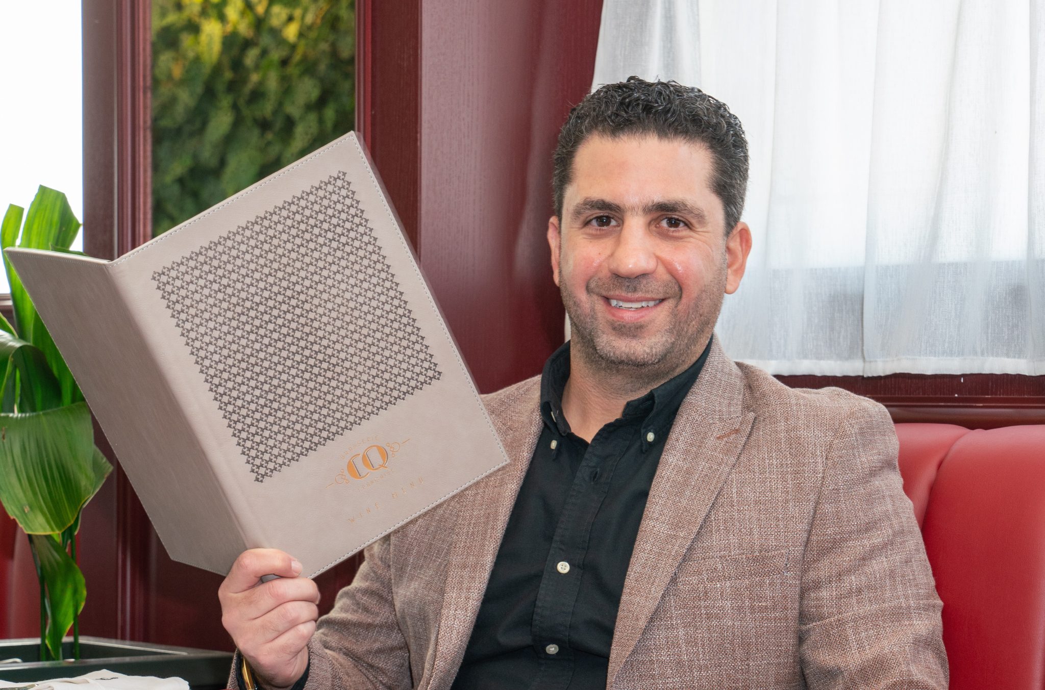 Ziad Kamel posing confidently in professional attire at restaurant.